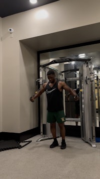 a man standing in front of a gym machine